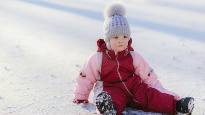 baby sitting in the snow