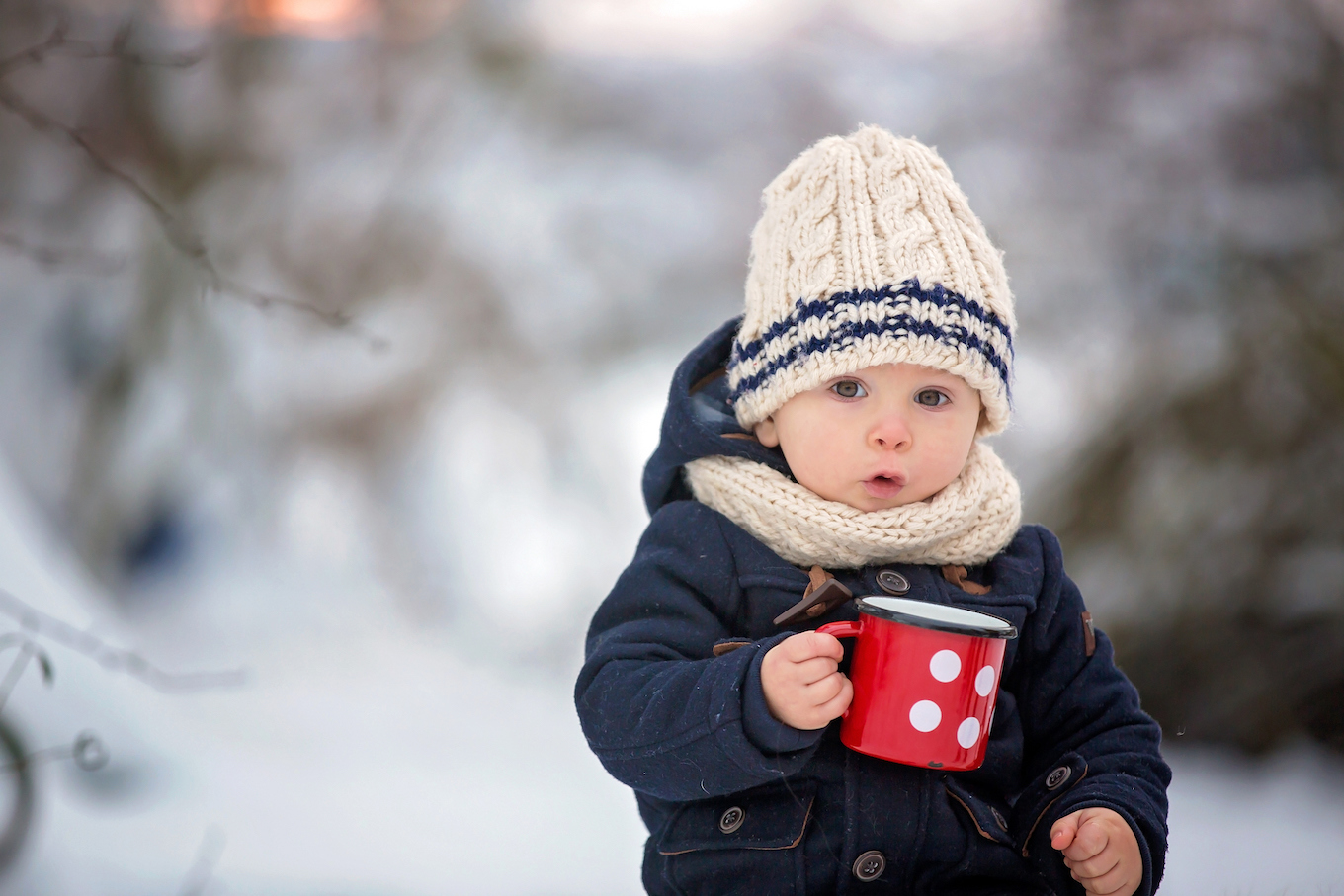Baby boy outside holding a mug