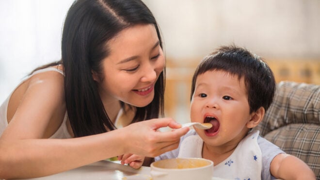 mom feeding baby solid food