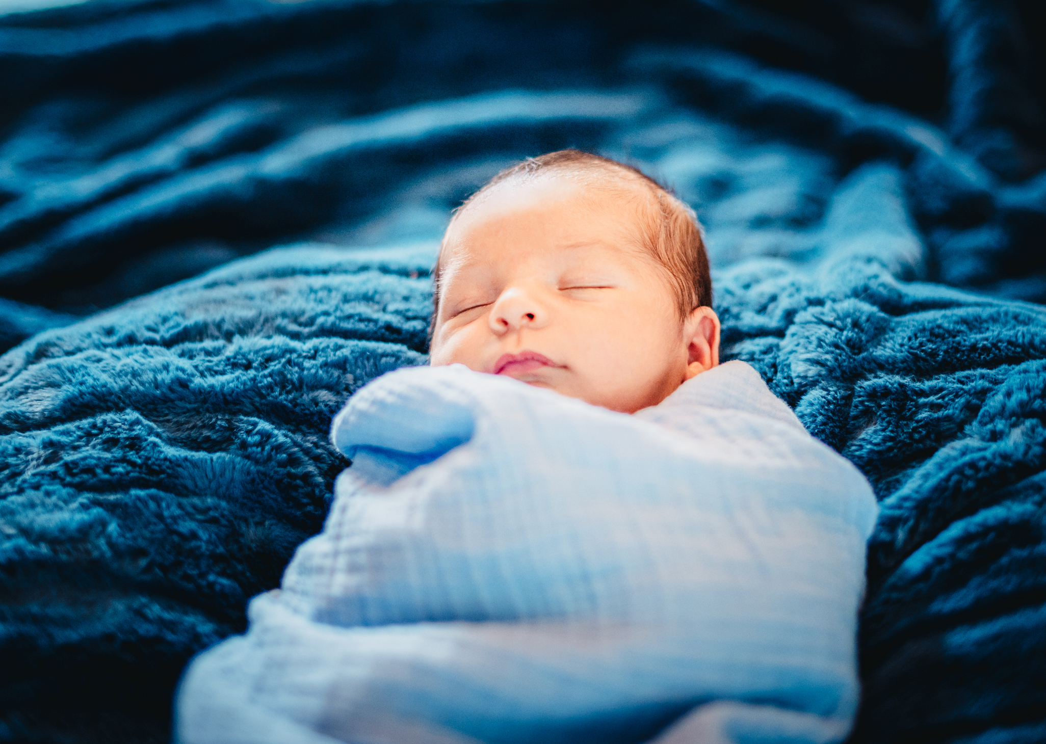 Latinx newborn baby in blue baby blanket
