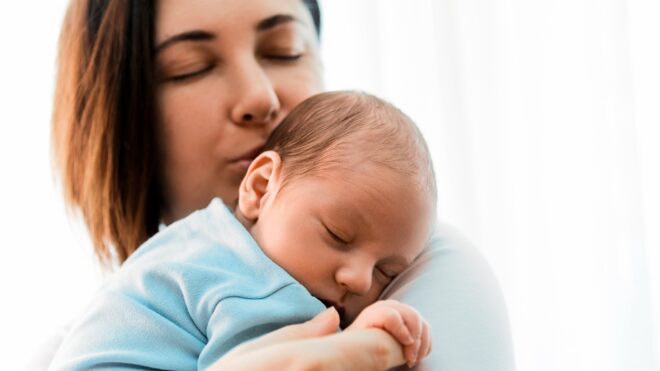mom and newborn baby cuddling