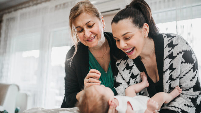 Changing baby's diapers, grandmother giving parenting advice