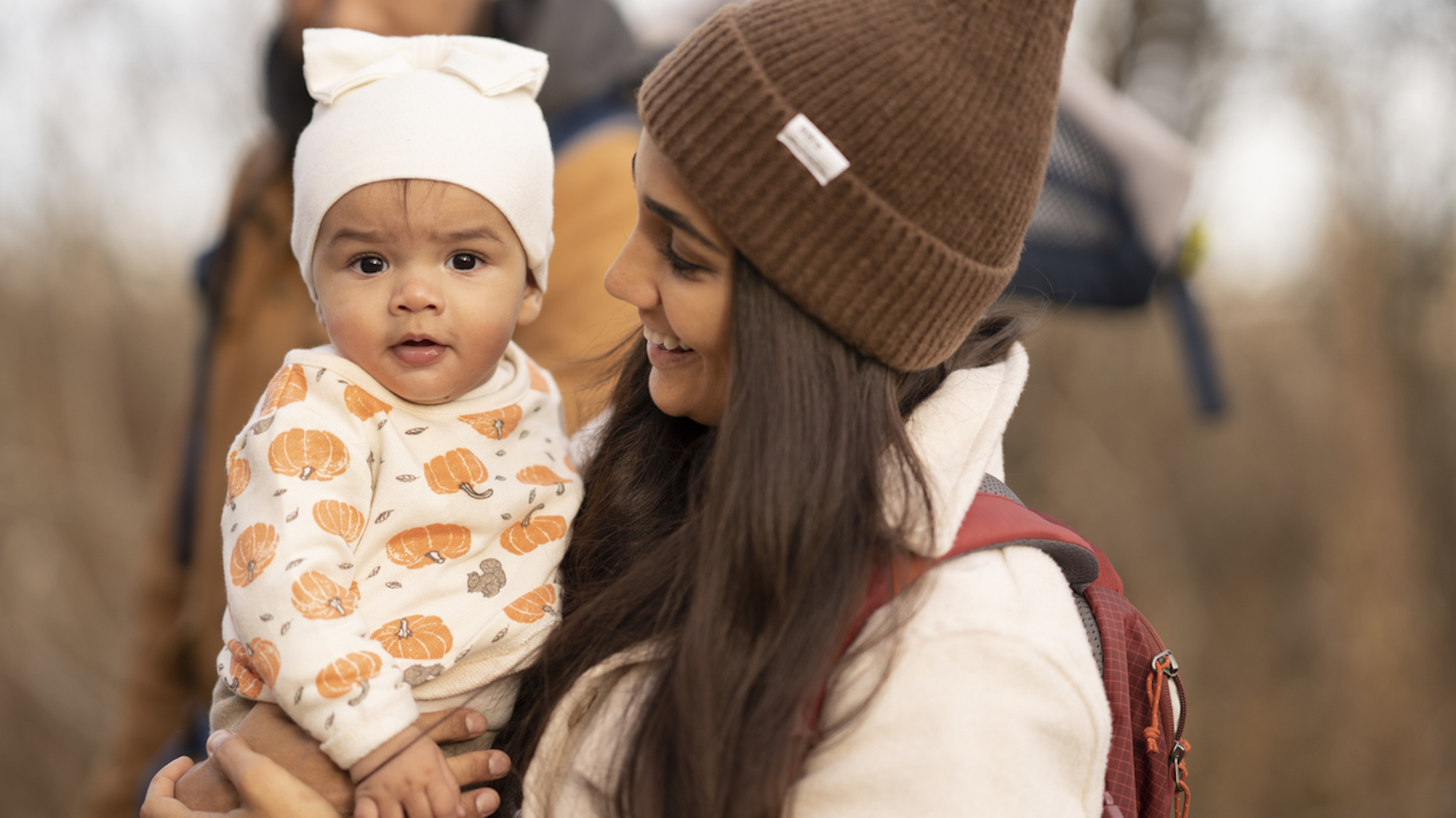 Baby in a pumpkin outfit with mom