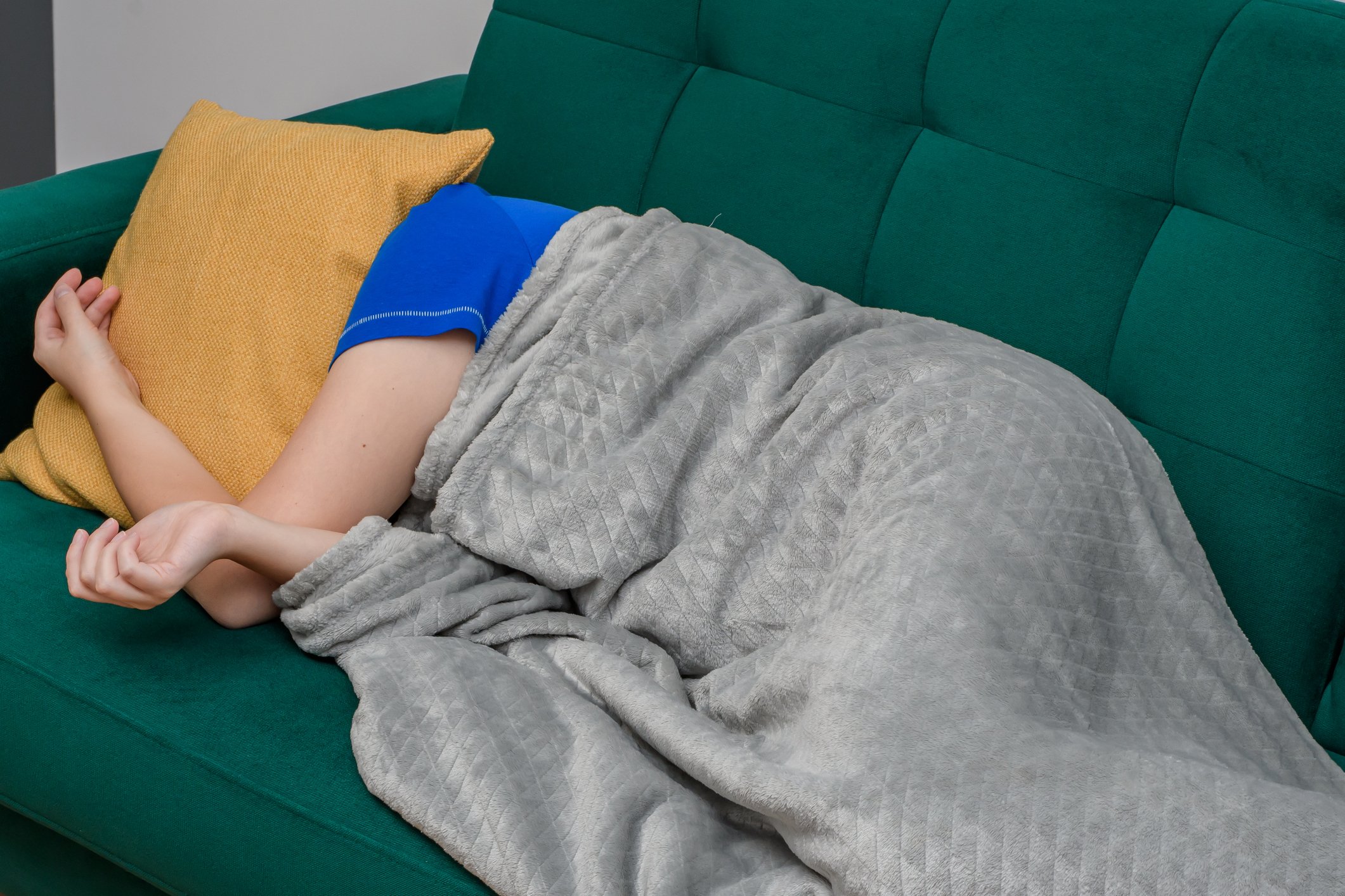 A person with sleep disorders sleeps on the sofa in the living room during the day